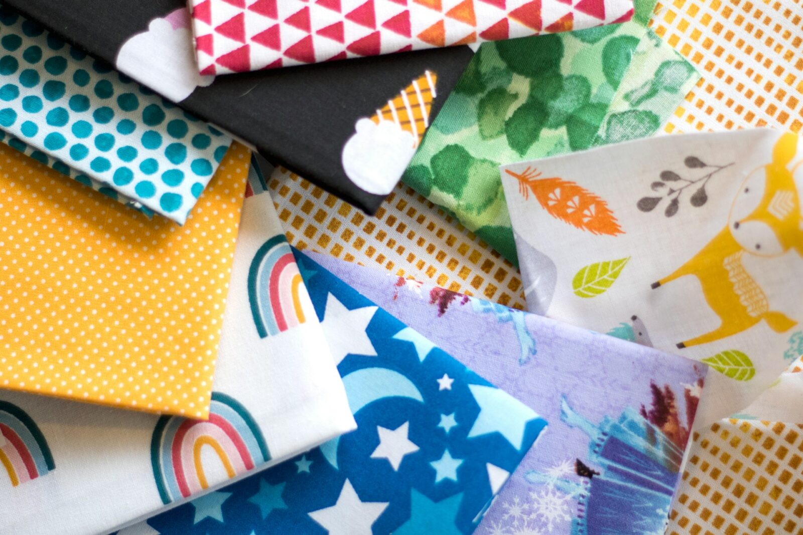 A pile of different colored fabrics on top of each other A pile of different colored fabrics on top of each other
